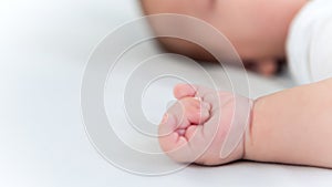 Hand of little baby on white sheet bed background. Cute boy and chubby hands
