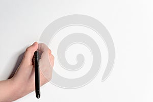 Hand of a little boy with a black pen on a white background