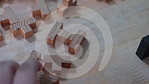 Hand a little boy playing wooden blocks toy in living room at home