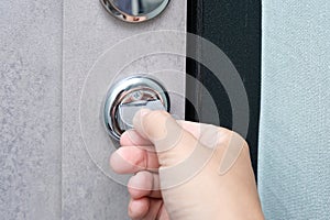 A hand locking the door with a door knob for security, protection and privacy