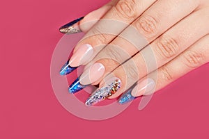 Hand with long artificial blue french manicured nails