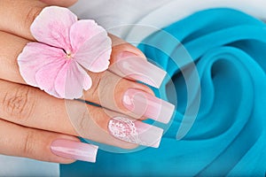Hand with long artificial manicured nails with ombre gradient design