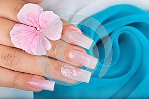 Hand with long artificial manicured nails with ombre gradient design photo