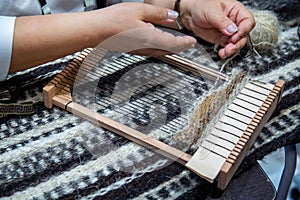 A hand loom for making tapestries with the hands of a craftswoman.