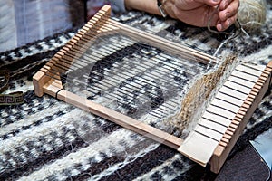 A hand loom for making tapestries with the hands of a craftswoman.