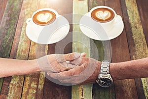 Hand love of ole couple in coffee shop