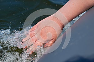 The hand is lowered into the water from an inflatable boat.