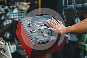 Hand of machine engineer are pressing button power execute machine.