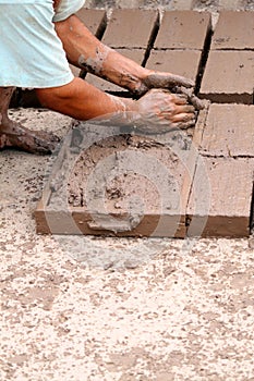 Hands of worker making bricks