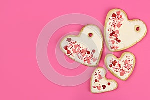 Hand made cookie hearts on a pink background, copy space