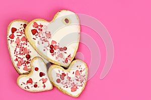 Hand made cookie hearts on a pink background, copy space