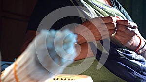 Hand made cotton wicks with person image rolling cottons for Diwali oil lamp in India. - rack focus shot