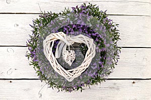 Hand made decoration wreath made of dry wooden twigs sticks and flowers hanging on white wooden wall