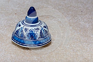Hand made Dutch Delft Blau blue ornament with blue flower designs and porcelin china on an isolated beige background.