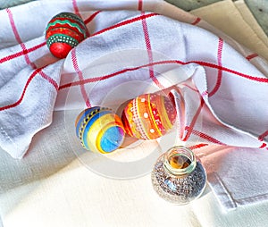 Hand made Easter souvenir eggs with embroidered patterns on kitchen table