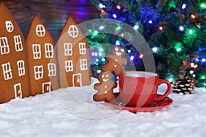 The hand-made eatable gingerbread houses, snow decoration,  little men and cup of coffee, New Year Tree