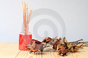 Hand made of Fragrance Diffuser Set: bottle with aroma sticks and dry red rose reed diffusers, a spray bottle with perfume on pi photo