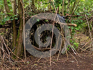Hand made hut in a green forest. Made from local wood and some plastic bag. Concept primitive building photo