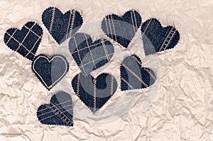 Hand made Jeans hearts on a crumpled craft paper background. Flat lay, top view, minimal style, copy space for text. Symbol of lov