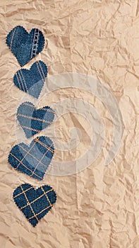 Hand made Jeans hearts on a crumpled craft paper background. Flat lay, top view, minimal style, copy space for text. Symbol of lov