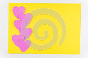 Hand-made pink love hearts isolated on yellow texture background, Happy valentine`s day. holiday background, Flat lay