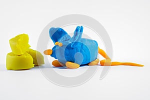 hand made plasticine play dough model of a mouse and cheese isolated on a white background