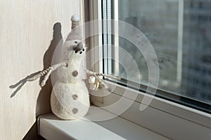 Hand made snowman toy near the window. Winter cristmas season