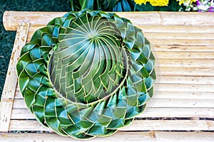 Hand made weaved hat, pleated from coconut palm leafs on a bamboo table