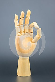 Hand made of wood Three index fingers upwards. The other 2 fingers of the hand meet in a circular OK.