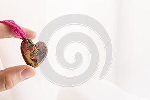 Hand-made wooden heart in female hands.