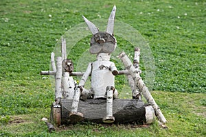 hand-made wooden sculpture of birch on the background of grass in the Park