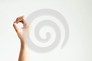 A hand making circle shape; or showing number zero by using thumb touching other fingers on white background