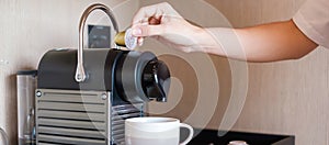 Hand making Espresso by Coffee Machine with capsules on wood table