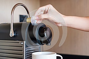 Hand making Espresso by Coffee Machine with capsules on wood table