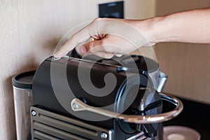 Hand making Espresso by Coffee Machine with capsules on wood table