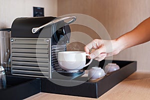 Hand making Espresso by Coffee Machine with capsules on wood table