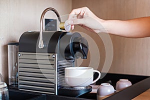 Hand making Espresso by Coffee Machine with capsules on wood table