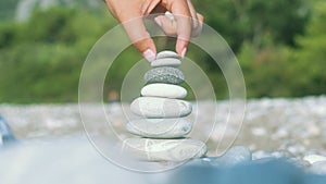 Hand making stone balance at sea beach. Spiritual harmony concept