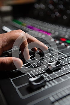 Hand of male audio engineer using sound mixer