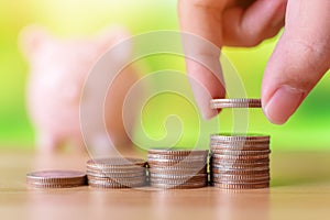 Hand of male or female putting coins money stack step growing growth saving money with piggy bank