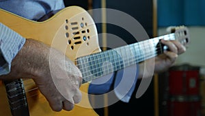 Hand of male musician playing on acoustic guitar