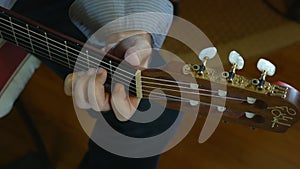 Hand of male musician playing on acoustic guitar