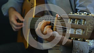 Hand of male musician playing on acoustic guitar