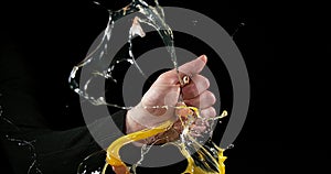 Hand of man breaking a chicken egg against black background,