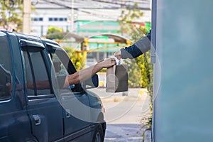 Hand Man in car receiving food in drive thru fast food restaurant.