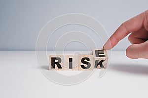 Hand of a man changing wooden blocks with the words Risk and Rise. Enterprise risk management and growth performance. Risks