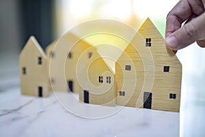 Hand of man choosing mini wood house model, Planning buy Real Estate