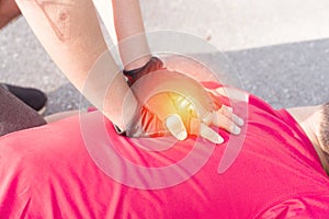 hand of man gesture First Aid Emergency CPR on a Man wearing red shirt after exercise on public park background who has