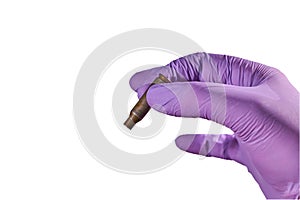 The hand of a man in a glove holding a bullet shell