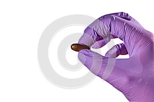 The hand of a man in a glove holding a bullet shell